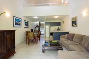 a living room with a couch and a table at Coral Sea Villas in Port Douglas