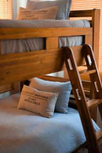 Litera de madera con silla y almohada en ZAITO Tokyo Kinshicho Economy Inn 宅东东京横川1民宿, en Tokio