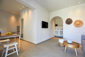 a living room with a table and chairs and a kitchen at Vigla Hotel in Aegiali