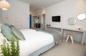 a bedroom with a bed and a desk with a tv at Vigla Hotel in Aegiali