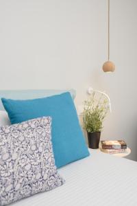 a bed with a blue pillow and a plant on it at Vigla Hotel in Aegiali