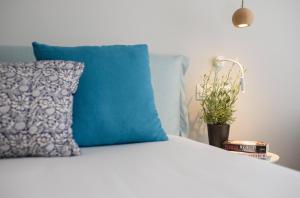 a bed with a blue pillow and a potted plant at Vigla Hotel in Aegiali