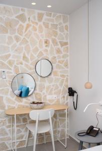 a room with a table and two mirrors on a stone wall at Vigla Hotel in Aegiali