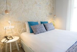 a bedroom with a bed and a phone on a table at Vigla Hotel in Aegiali
