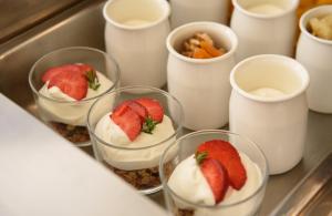 a group of cups with strawberries and whipped cream at Vigla Hotel in Aegiali