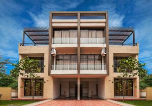 a tall building with two balconies on it at StayVista's Greenwoods Villa 10 - City-Center Villa with Private Pool, Terrace, Lift & Carrom Board in Lonavala