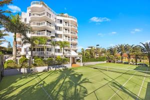 a tennis court in front of a building at Beachside Resort Kawana Waters in Buddina