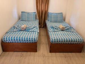 two beds sitting next to each other in a room at Inngo Tourist Inn in El Nido