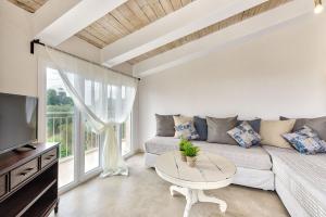 a living room with a couch and a table at JARDIN de VILLE in Lithakia