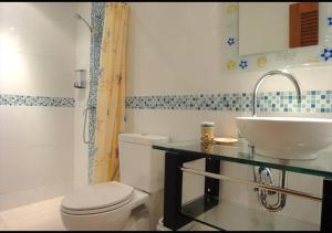 a bathroom with a white toilet and a sink at Patong Karlssons Hotel in Patong Beach