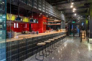 a restaurant with a bar with a red wall at AZIMUT Hotel Siberia in Novosibirsk