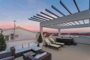 a rooftop patio with couches and a fireplace at VILLA NICOLINA in Kaštela