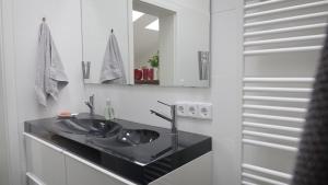 a bathroom with a black sink and a mirror at Ferienwohnung Tulpenweg in Bad Zwischenahn