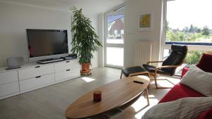 a living room with a tv and a table at Ferienwohnung Tulpenweg in Bad Zwischenahn