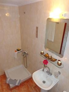 a white bathroom with a sink and a mirror at Niki Studios Sea - Front in Petra