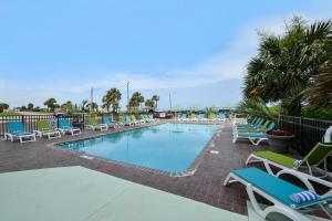 a swimming pool with lounge chairs and a resort at The Mermaid Inn in Myrtle Beach