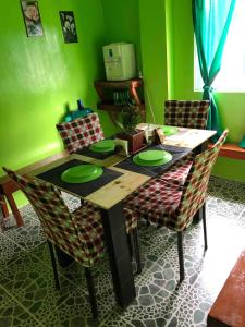 a dining room table with green walls and chairs at ALERTA ROOFTOP LODGE in Magdiwang +41 photos