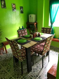 MagdiwangALERTA ROOFTOP LODGE的配有木桌椅的餐厅 更多38张照片