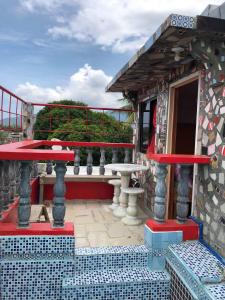 einen Balkon eines Hauses mit einem Tisch und einer Bank in der Unterkunft ALERTA ROOFTOP LODGE in Magdiwang
