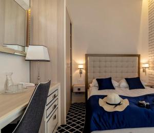 a bedroom with a bed with a hat on it at Willa Legenda Hotel Adults Only in Mielno