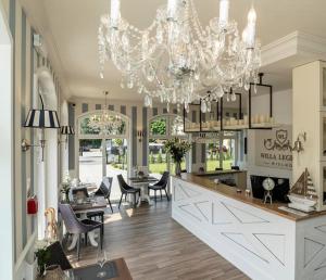 a kitchen with a chandelier and a dining room at Willa Legenda Hotel Adults Only in Mielno