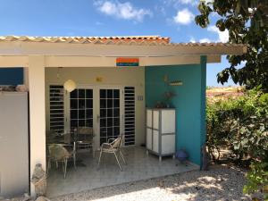 Cette petite maison dispose d'une terrasse avec une table et des chaises. dans l'établissement Droomstudio seru coral 32, à Willemstad