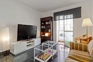 sala de estar con TV y sofá en Family Apartment, en Málaga