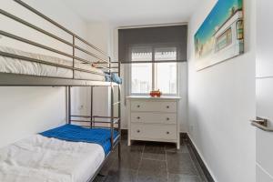 Dormitorio pequeño con litera y ventana en Family Apartment, en Málaga