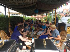 grupa ludzi siedzących przy stolikach w restauracji w obiekcie Chillout Holiday Home w Katmandu