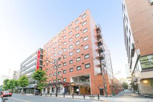 a tall red brick building on a city street at Akasaka Yoko Hotel in Tokyo