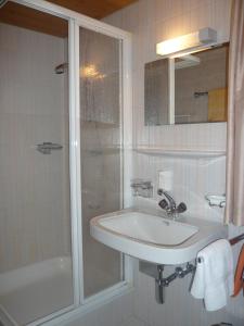 een witte badkamer met een wastafel en een douche bij Appart Fernblick in Gaschurn