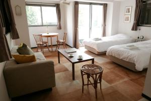 a living room with a bed and a couch and a table at Tokyo Sakurako Hatchobori in Tokyo