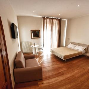 1 dormitorio con 1 cama, 1 sofá y 1 silla en Alsecondopiano B&B, en Gioia del Colle