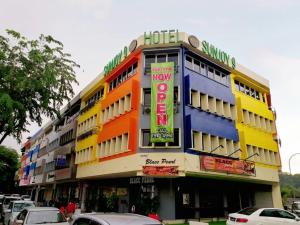 un bâtiment d'hôtel avec des voitures garées devant lui dans l'établissement Hotel Sunjoy9 @ Mid Valley, à Kuala Lumpur