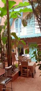 un patio con mesa, sillas y árboles en Riad Dar Mchicha by phoenix, en Marrakech