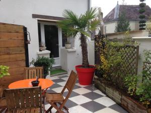 a patio with a table and chairs and a palm tree at Appartement des Petits Princes in Valençay +4 photos