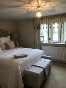 a bedroom with a large white bed and windows at Church Gate Farm in Harrogate