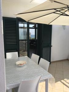 een tafel en stoelen met een tafel en een parasol bij Villa Irene in Torre Santa Sabina