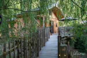 a wooden walkway leading to a house with a fence at Les Cabanes du Beau Vallon in Profondeville