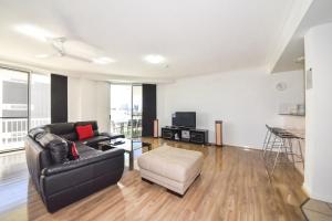 - un salon avec un canapé et une chaise dans l'établissement Founda Gardens Apartments, à Brisbane