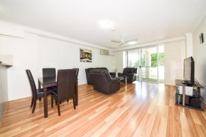 a living room with a table and chairs at Founda Gardens Apartments in Brisbane