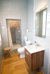 Oporto Sky Hostel في بورتو: حمام مع مرحاض ومغسلة ومرآة