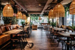 a row of tables in a restaurant with pendant lights at Original Sokos Hotel Puijonsarvi in Kuopio