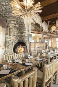 a dining room with a large table and a fireplace at Résidence Les Balcons de Val Cenis Village in Lanslevillard