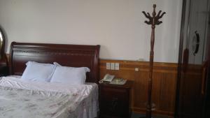 a bedroom with a bed and a phone on a table at Hue Railway Hotel in Hue +3 photos