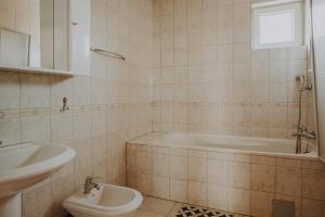 a bathroom with a tub and a toilet and a sink at Noćko-Sobe i apartmani in Vukovar