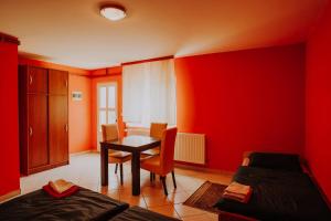 a room with red walls and a table and chairs at Noćko-Sobe i apartmani in Vukovar