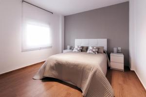 a white bedroom with a bed and a window at Apartamento La Terraza del Mar in Cádiz
