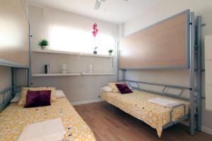 a room with two beds and a large window at Apartamento Playa Victoria Cadiz in Cádiz