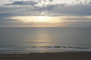 a group of people standing on a beach near the ocean at Apartamento Playa Victoria Cadiz in Cádiz